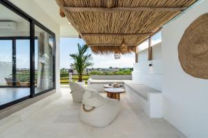 a living room with white furniture and large windows at Villa Le Blanc - Tropical Luxury 3BR Villa with Pool & Rooftop Views in Tumbak Bayuh in Tumbak Bayuh