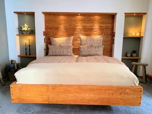 OrlamündeNeles Nest的卧室里有一张带木质床头板的大床