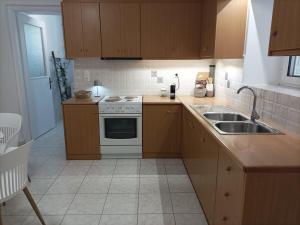 a kitchen with wooden cabinets and a stove and a sink at Petrochori Memories Maisonette in Petrochori +28 photos