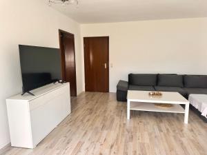 a living room with a couch and a table at Schöne Ferienwohnung mit Waldblick in Dillenburg in Dillenburg