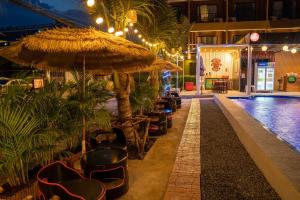 a resort with a swimming pool with chairs and an umbrella at 105 Residence Rangsit in Ban Talat Rangsit