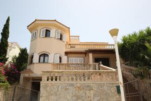 Una casa grande con balcón y farola. en Your Island Villa Son Serra, en Son Serra de Marina