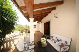 un porche con 2 sillas y una mesa en Your Island Villa Son Serra, en Son Serra de Marina