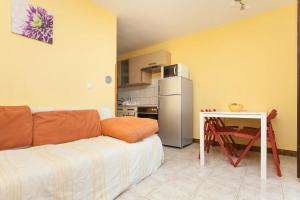 a living room with a couch and a small kitchen at Apartment Jenul in Labin +20 photos