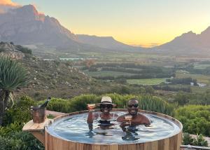 two people in a hot tub with the mountains in the background at 7 Koppies in Franschhoek