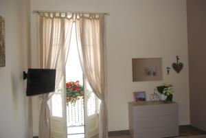 una finestra con tende e una televisione in camera di Casa di nonna Gina a Agrigento