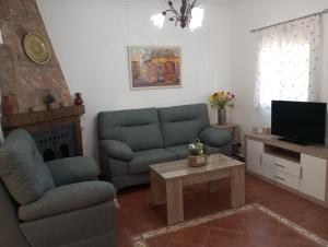 a living room with a couch and a tv at Casa Rural Mi Cortijo in Nerja