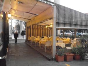 a restaurant with yellow tables and chairs on a sidewalk at Hotel Dell'Orto in Chiavari