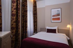 Postel nebo postele na pokoji v ubytování Opera Hotel