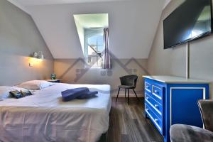 a bedroom with a bed with a blue dresser and a tv at LocaLise - Maison G4 au Guilvinec - A 50m de la mer avec jardin et piscine - Tout à pied, plages, port, centre, commerces, marché - Wifi inclus - Animaux bienvenus - Linge de lit inclus in Le Guilvinec +59 photos