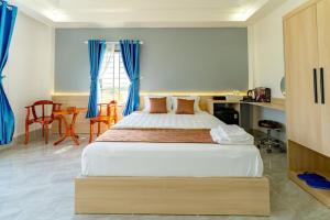 een slaapkamer met een groot bed met blauwe gordijnen bij Gia Phú Hotel Bình Thuận in Tánh Linh +28 foto's