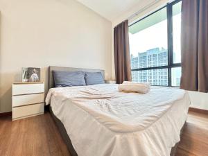 ein Schlafzimmer mit einem Bett und einem großen Fenster in der Unterkunft Central Park Tampoi 2 bedroom by Luxecocoo CK in Johor Bahru