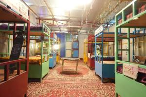 une pièce avec de nombreux lits superposés et une table à l'intérieur dans l'établissement Happy Hippy Hub by Yatrimap, à Jāmb