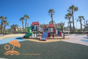 a playground with a slide in a park with palm trees at Patacona Resort Apartments Primera Linea in Valencia
