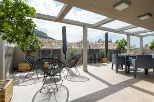 a patio with chairs and tables on a roof at Trikoupi 95 in Athens