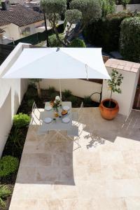 a table with a white umbrella in a courtyard at Splendid 3-bedroom villa for 6 people in Saint-Tropez
