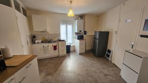 a kitchen with white cabinets and a black refrigerator at La Tanière Sedanaise 2 bedrooms parking wifi in Sedan +16 photos