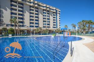 a swimming pool in front of a building at Patacona Resort Apartments Primera Linea in Valencia