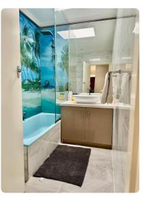 a bathroom with a sink and a tub and a mirror at Jalynn 1 Cottage in Glen Waverley +24 photos