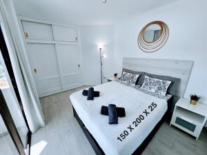 a bedroom with a white bed with black pillows at OCEAN VIEW - renovation 2025 in Playa del Cura