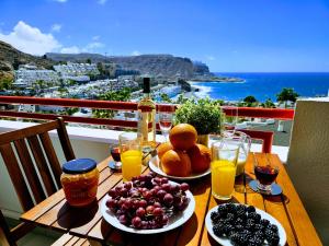 a table with plates of fruit and glasses of orange juice at OCEAN VIEW - renovation 2025 in Playa del Cura