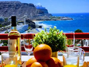 a table with a bottle of wine and some oranges at OCEAN VIEW - renovation 2025 in Playa del Cura +45 photos