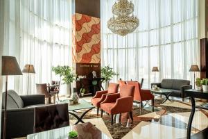a lobby with couches and chairs and a chandelier at Kingsgate Hotel Doha by Millennium Hotels in Doha