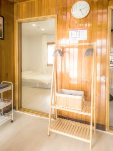 a room with a mirror and a clock on the wall at A spacious and pleasant accommodation for up to 10 people, Haeundae station walking 6 minutes and beach walking 8 minutes in Busan