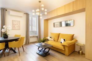 a living room with a yellow couch and a table at Pick A Flat's Apartments in Batignolles - Rue Gauthey in Paris