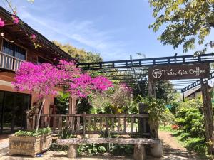 a wooden bench in front of a building with pink flowers at Trần Gia Homestay in Văn Chấn +24 photos