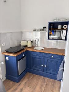 a small kitchen with blue cabinets and a sink at Guestroom 10 in Willich in Willich