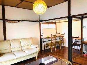 鹿児島市にあるGrandma's House Kakuregaの白いソファとテーブルのあるリビングルーム