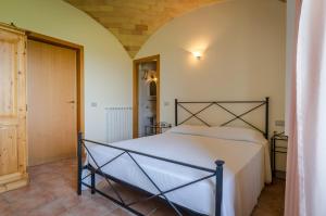 
a white bed sitting in a bedroom next to a wall at Agriturismo Agrimare Barba in Pineto
