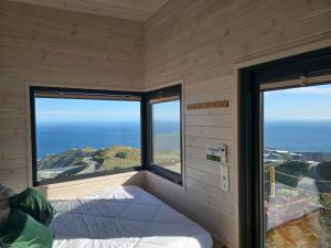 a room with two large windows with a bed in it at De la Luz Ecolodge by Tiny Away in Polopos