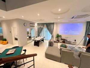 a living room with a couch and a pool table at Fairy 2 Pool Villa 22 Pax Karaoke & Huge Event Space in Ipoh