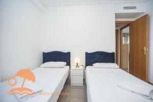 a bedroom with two beds with white sheets at Patacona Resort Apartments Primera Linea in Valencia