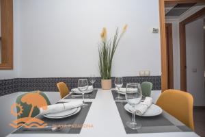 a dining room table with wine glasses and chairs at Patacona Resort Apartments Primera Linea in Valencia