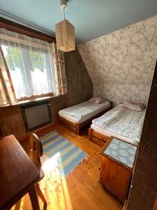a small room with two beds and a table at Dom pod Cuplikiem in Zawoja