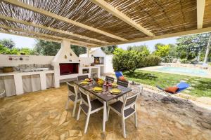 eine Außenküche und ein Esszimmer mit Tisch und Stühlen in der Unterkunft Villa Agata Salentino by Villa Plus in San Michele Salentino