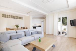 a living room with a white couch and a table at Villa Alena by Villa Plus in Kalami