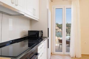a kitchen with a counter top with a microwave at Villa Alena by Villa Plus in Kalami