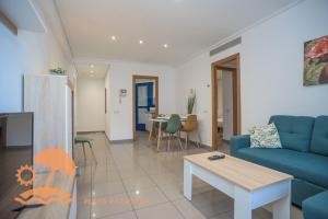 a living room with a blue couch and a table at Patacona Resort Apartments Primera Linea in Valencia