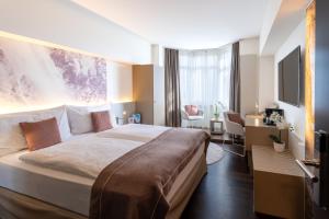 una camera d'albergo con un letto grande e una scrivania di Cascada Boutique Hotel a Lucerna