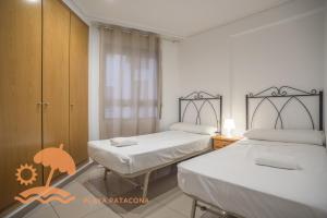 a bedroom with two beds and a window at Patacona Resort Apartments Primera Linea in Valencia