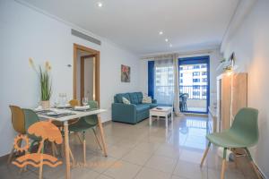a living room with a table and chairs and a couch at Patacona Resort Apartments Primera Linea in Valencia