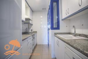 a kitchen with a sink and a counter top at Patacona Resort Apartments Primera Linea in Valencia