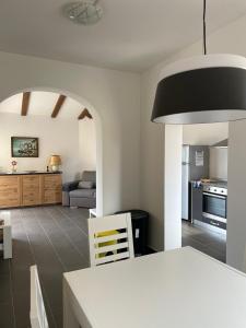 a kitchen and living room with a white table and a room at Apartment Mali raj in Medulin