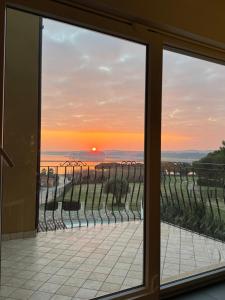 a view of a sunset from a window at Apartment Mali raj in Medulin