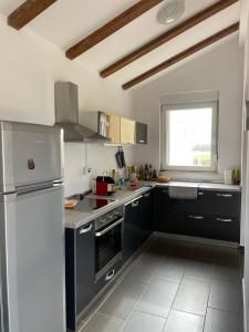 a kitchen with black and white appliances and a window at Apartment Mali raj in Medulin +3 photos