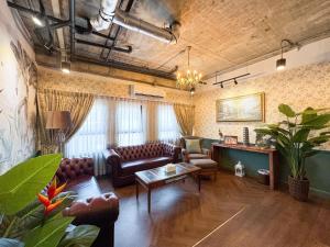 a living room with couches and a table at Nara Poshtel Sathorn in Bangkok